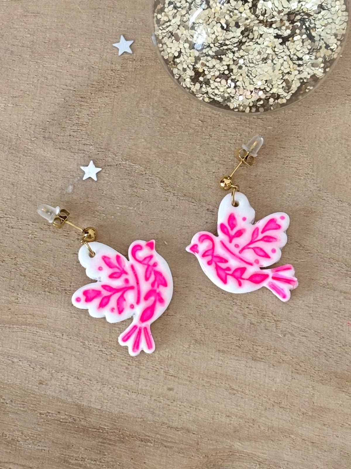 Boucles d’oreilles pendantes oiseaux blancs et motifs rose fluo