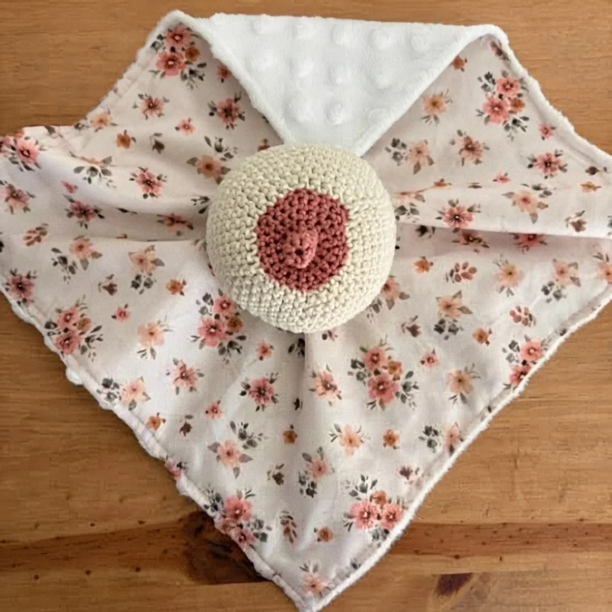 Doudou d'allaitement carré à fleurs roses et blanches avec sein en crochet au centre