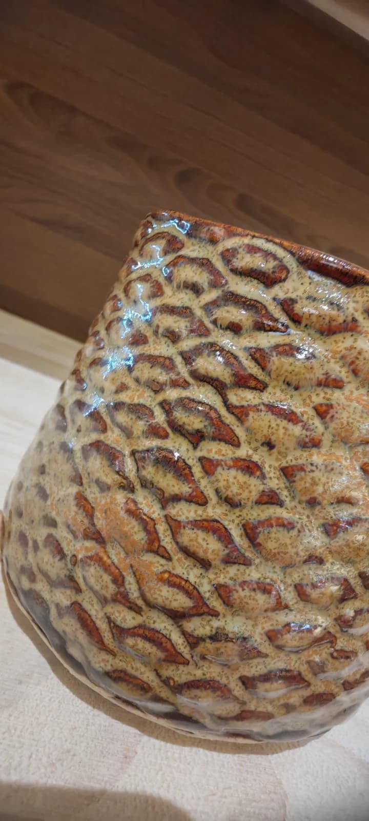 Gros plan sur les détails en relief et l'émail marron et beige texturé de la tasse en céramique