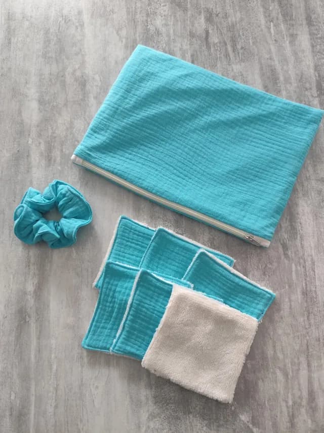 Kit beauté turquoise avec pochette zippée, chouchou assorti et lingettes lavables à face blanche.